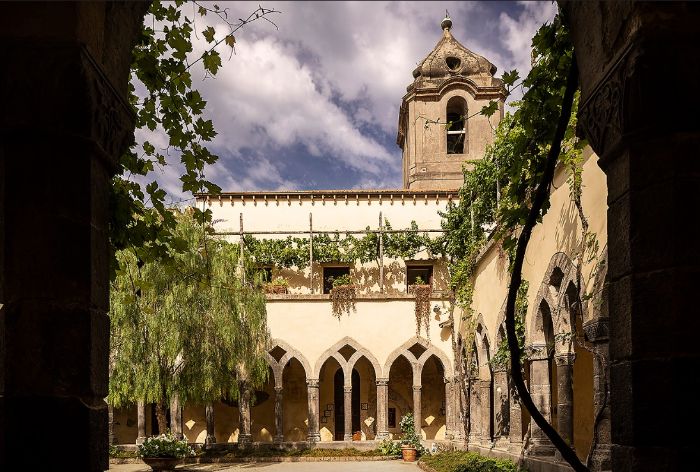 Garden, pointed arches and bell tower at the cloister of San Francesco in Sorrento