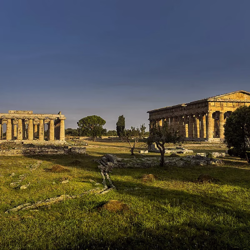 Ancient Greek temples at Paestum in Cilento, near Naples, with columns glowing under the afternoon light.