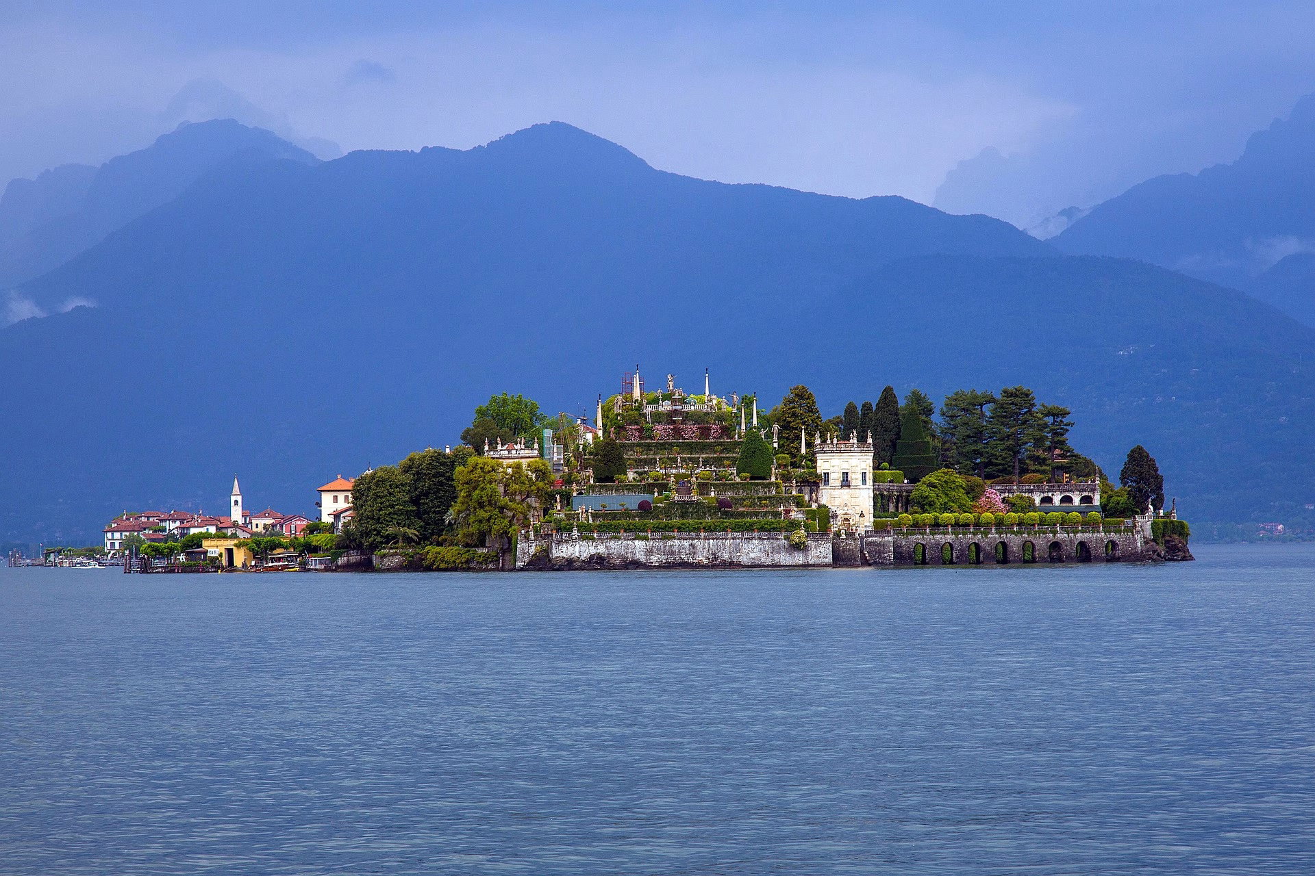 Isola Bella’s terraced gardens seen across Lake Maggiore, with mountains behind.