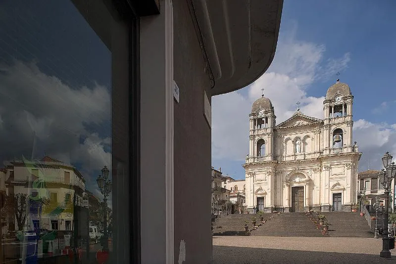 The Chiesa Madre di Santa Maria della Provvidenza in Zafferana Etnea, a grand baroque-style church with twin bell towers, standing at the top of a wide staircase in the town’s main square.