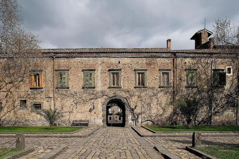 The historic Duchy of Bronte, also known as Nelson’s Castle, a former Benedictine abbey turned noble residence, gifted to Admiral Horatio Nelson, featuring a stone façade with arched entryways and shuttered windows.