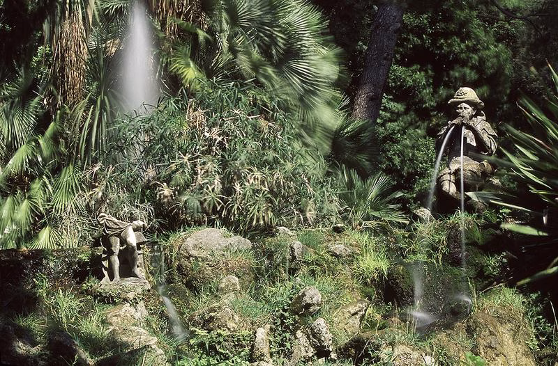 Statue fountain hidden among greenery in the English Garden of the Royal Palace of Caserta.