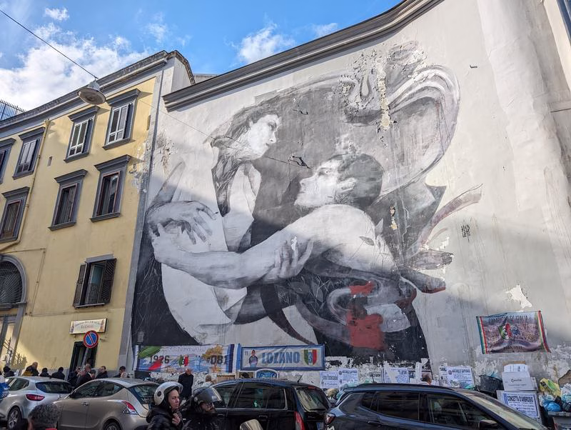 Street art mural in Rione Sanità, Naples, depicting an embracing couple, symbol of love and resilience in the neighbourhood.