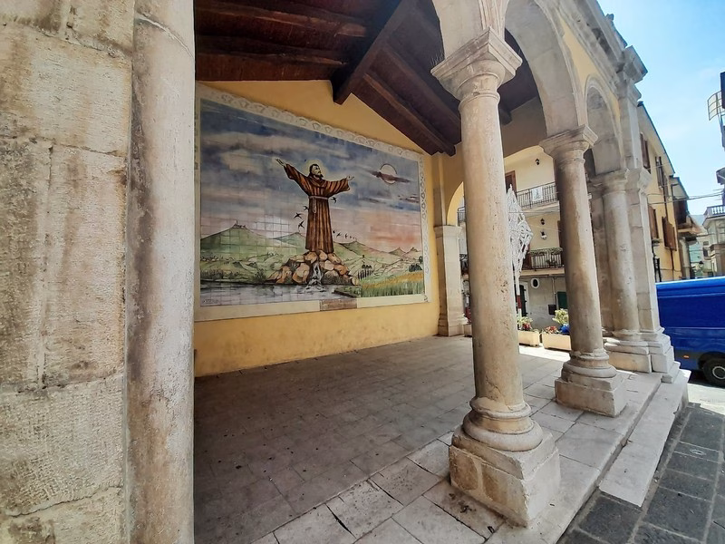 Ceramic mural of Saint Francis with open arms in a portico in Teggiano, Cilento.