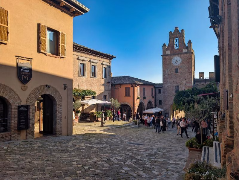 View of Gradara’s main square and clock tower on a sunny afternoon