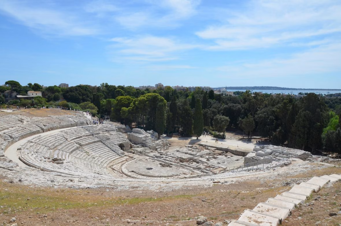 Wide view across the ancient Greek Theatre of Siracusa and its stone seating