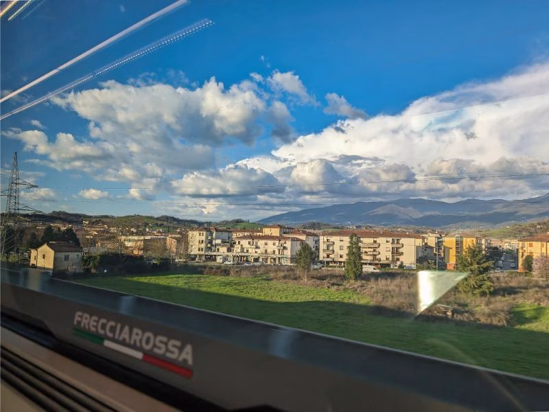 View from Frecciarossa train window passing Italian suburbs
