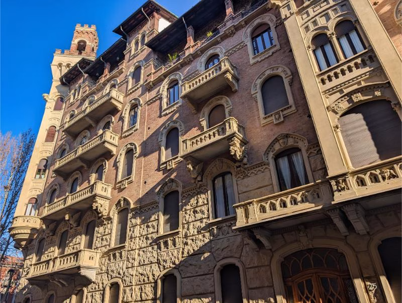 Casa della Vittoria upper structure and roofline, Turin Upper floors and roofline of Casa della Vittoria in Turin showing brickwork, balconies and neo-medieval detailing