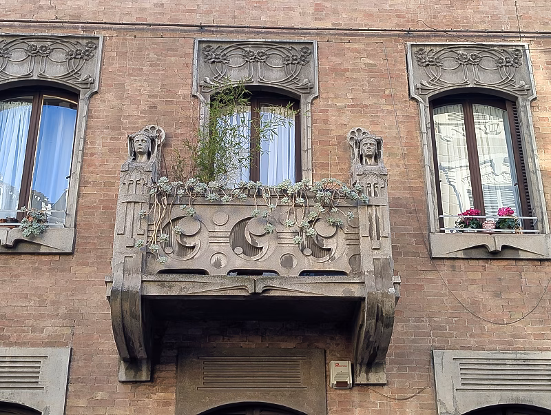 Liberty balcony detail, Turin Liberty balcony detail in Turin with sculpted stone balustrade, stylised female heads and geometric ornament set within a brick façade