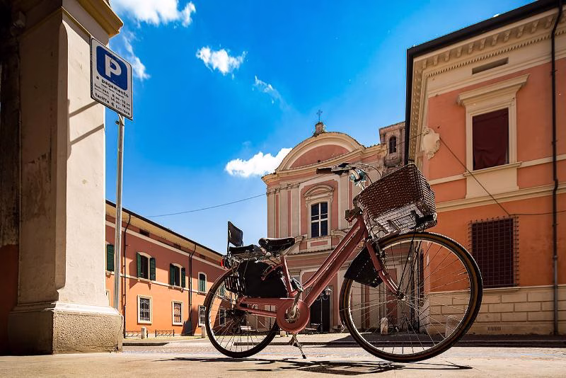 Unhurried movement Bicycle parked in a sunlit Italian piazza with pastel buildings