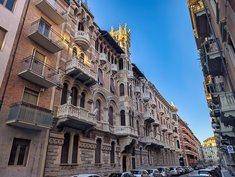 Liberty residential side street, Turin Early 20th-century Liberty apartment buildings in Turin along a narrow residential street with layered balconies and brick façades