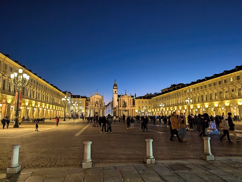 Piazza San Carlo in Turin at night with illuminated arcades and twin churches