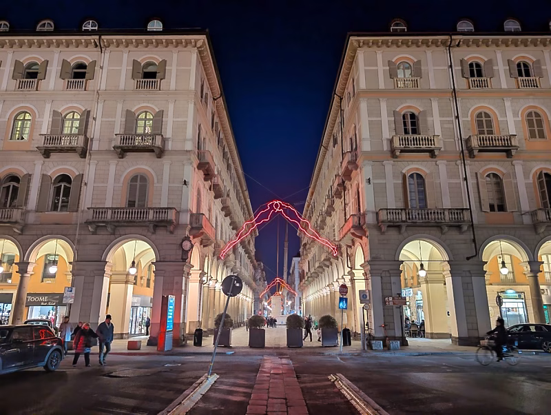 Via Garibaldi at night seen from Piazza Statuto, showing the long arcaded axis leading into the historic centre of Turin.