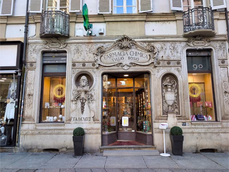 Historic Farmacia Chimica Tullio Bosio on Via Garibaldi in Turin, an ornate former chemist’s shop with a carved stone façade.
