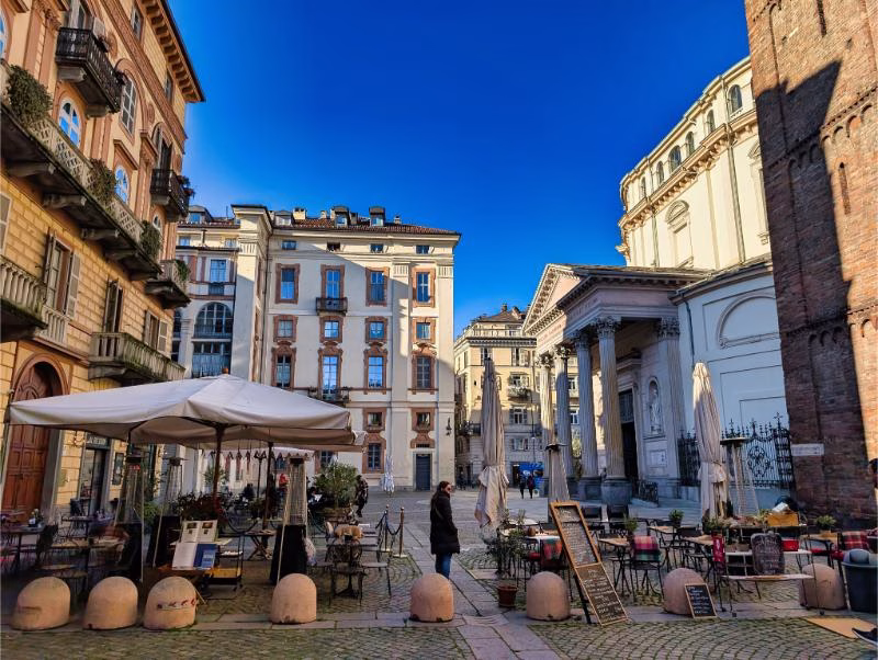 Piazza della Consolata in Turin, with café tables facing the Santuario della Consolata in the Quadrilatero Romano.