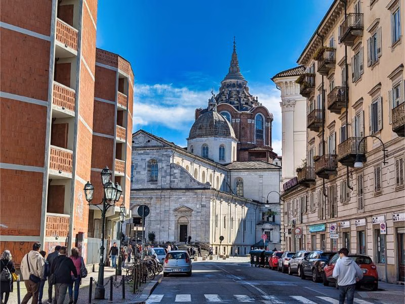 Street view in the Quadrilatero Romano in Turin, with historic buildings and daily pedestrian life.