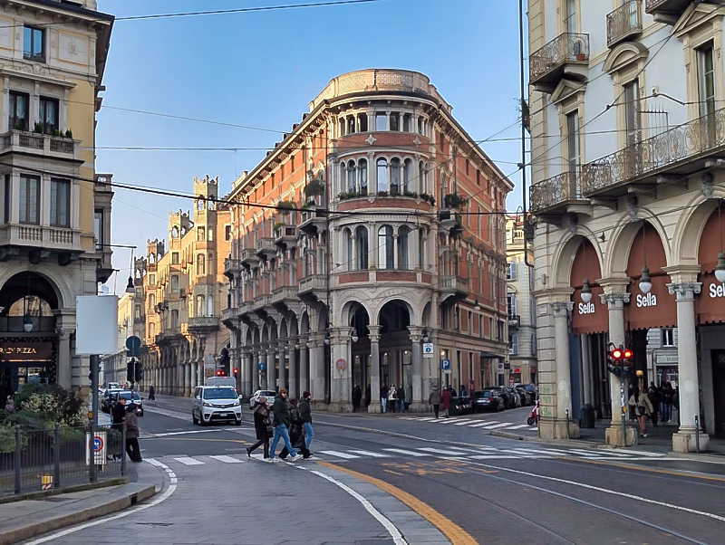 Via Pietro Micca in Turin, showing a diagonal street lined with late-19th-century palazzi and continuous porticoes.