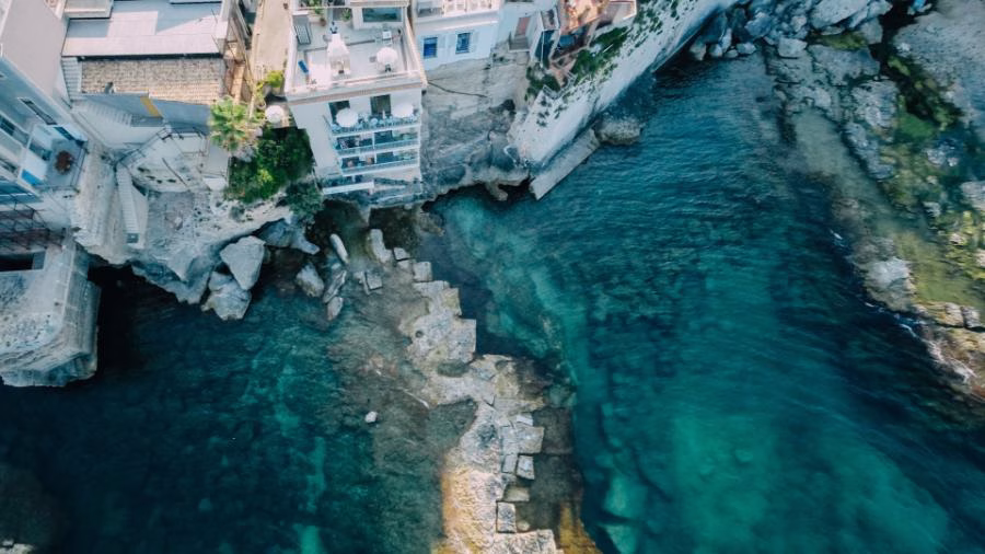 Aerial view of La Giuggiulena B&B above a rocky inlet in Siracusa