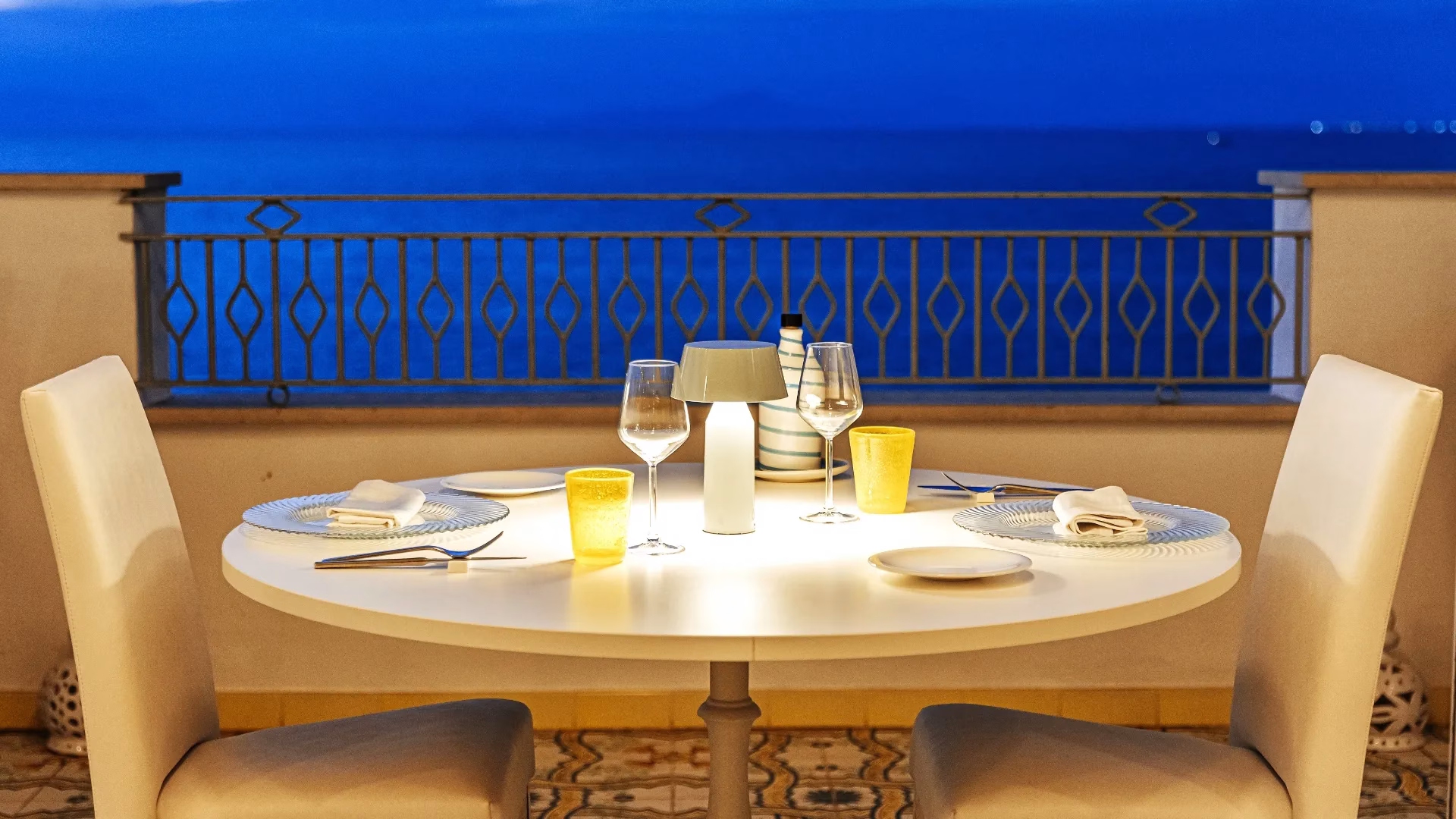 Candlelit sea-view dining terrace at La Madonnina Hotel in Ischia