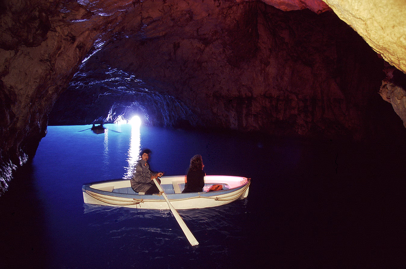 A rowing boat inside Capri’s Blue Grotto with blue light at the entrance