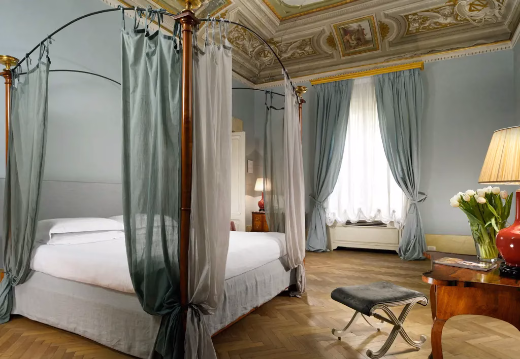 Four-poster bedroom with an ornate ceiling at Palazzo di Camugliano in Florence