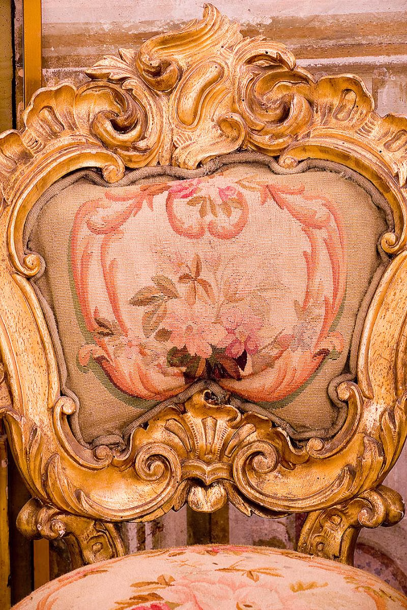 Carved gilded chair with floral upholstery at Palazzo Gangi