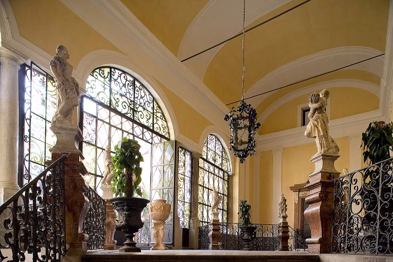 Palazzo Gangi staircase landing with statues, arched windows and iron balustrades