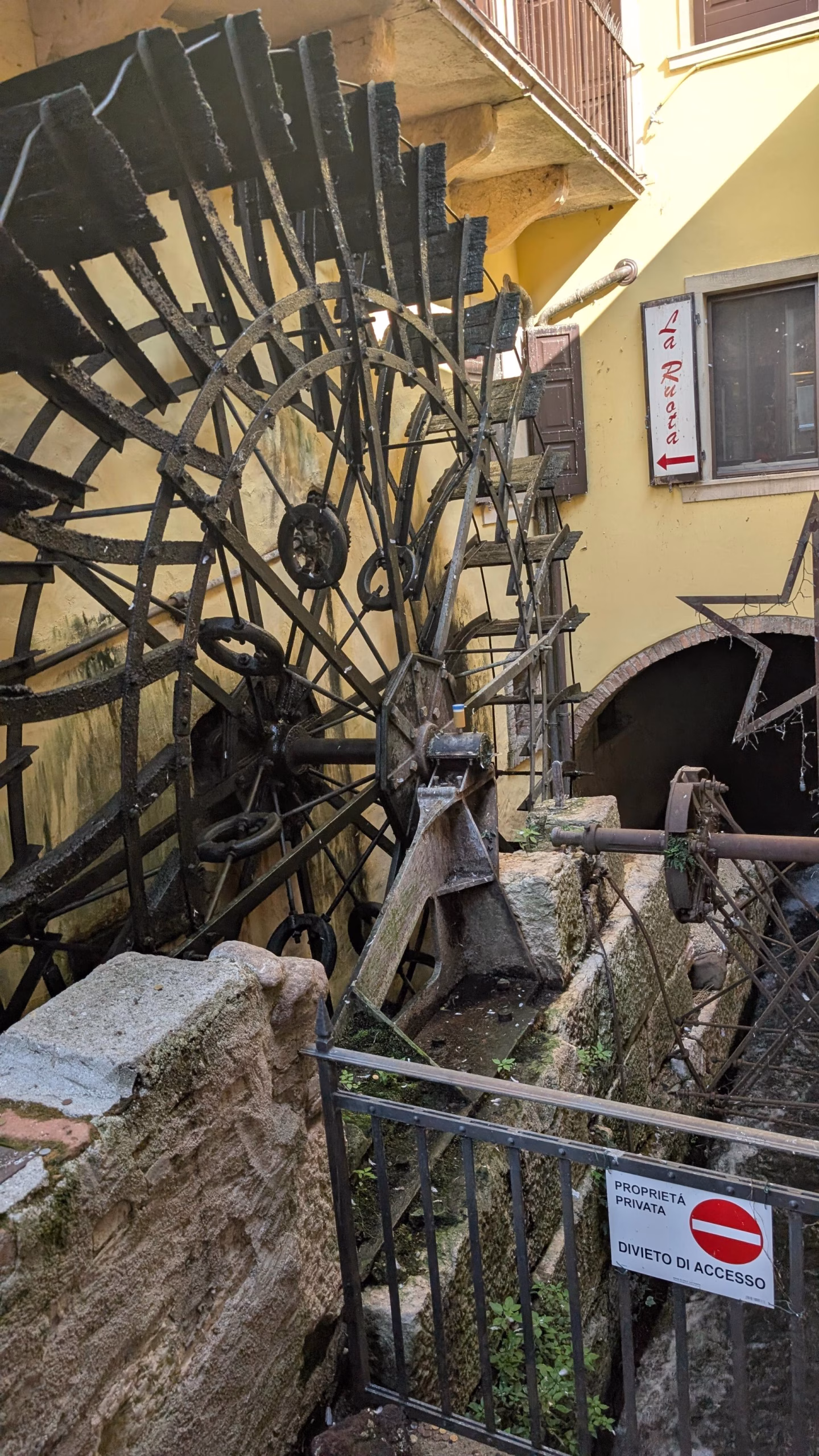 Old watermill wheel beside a stone building in Borghetto sul Mincio