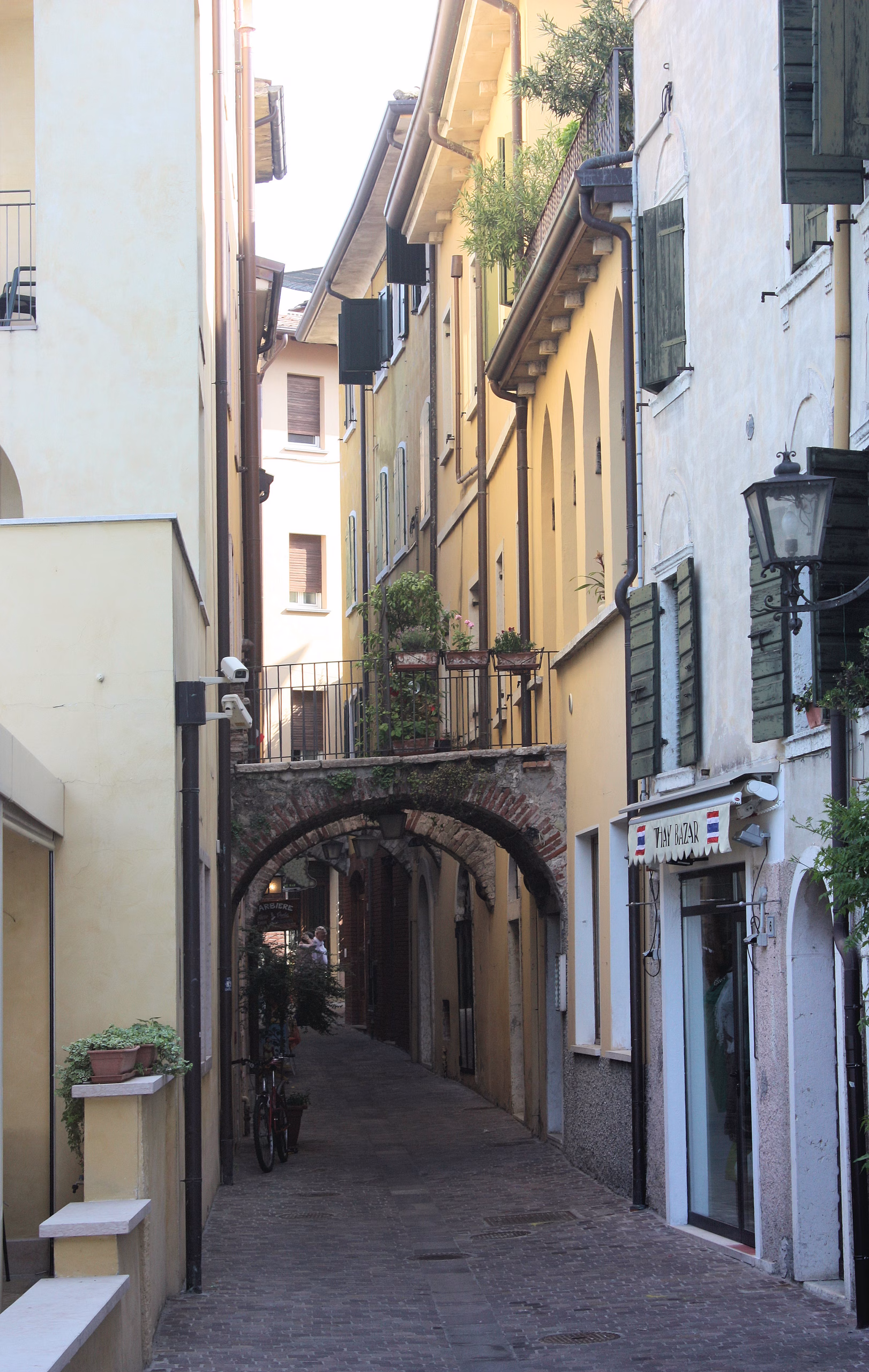 Stone archway and traditional façades along Calle dei Sottoportici in Garda town