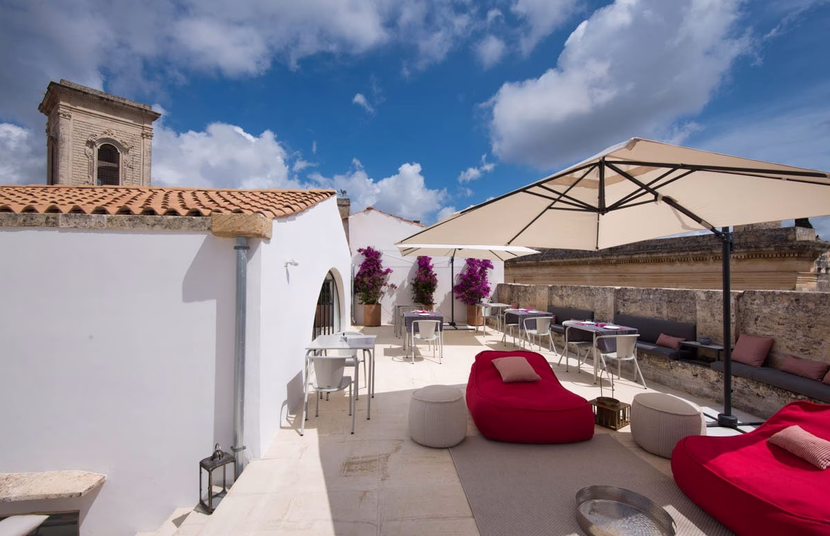 Rooftop terrace at Palazzo de Noha in Lecce, with parasols and seating