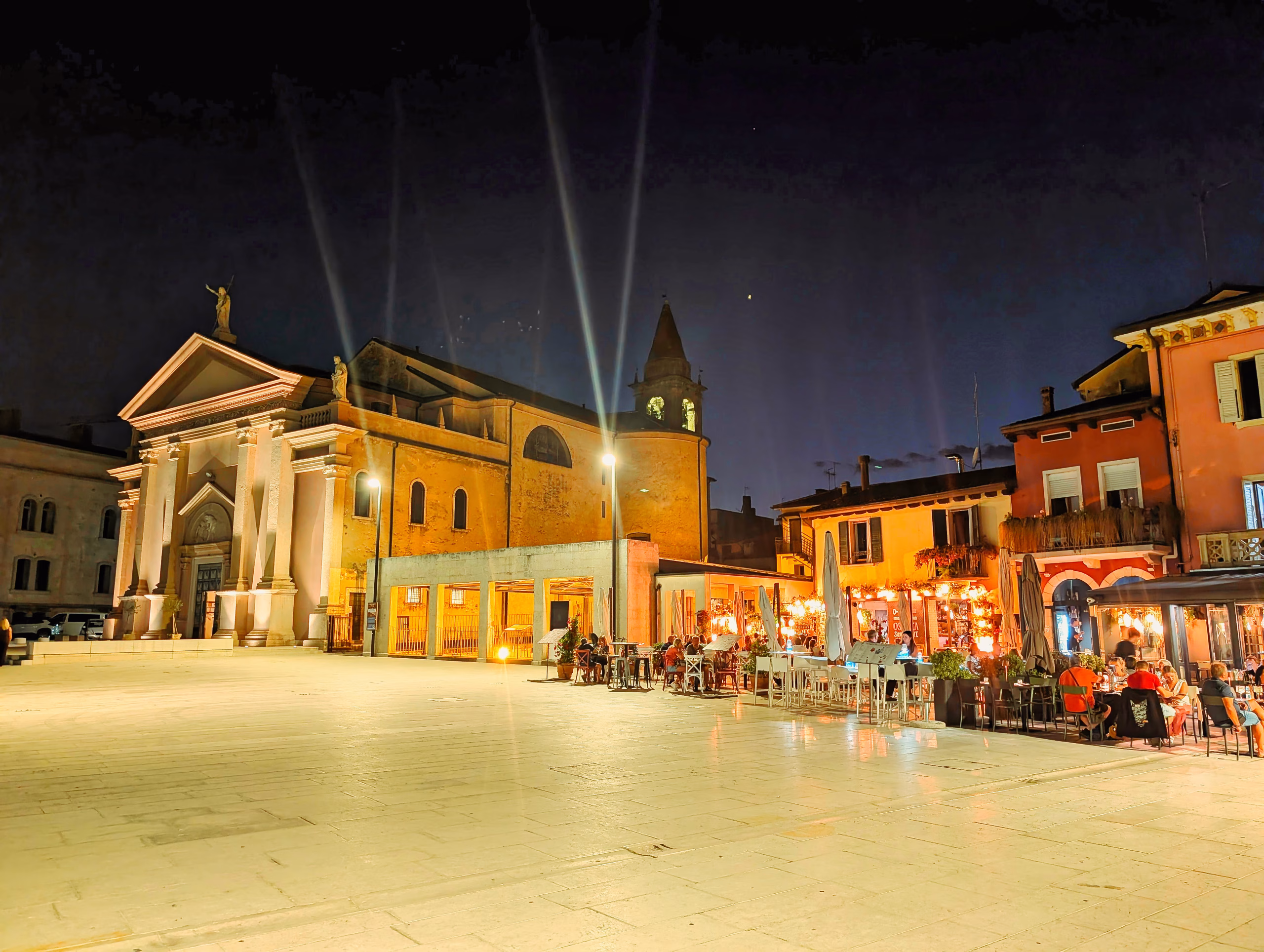 The illuminated Church of San Martino and café tables in Piazza Ferdinando di Savoia at night