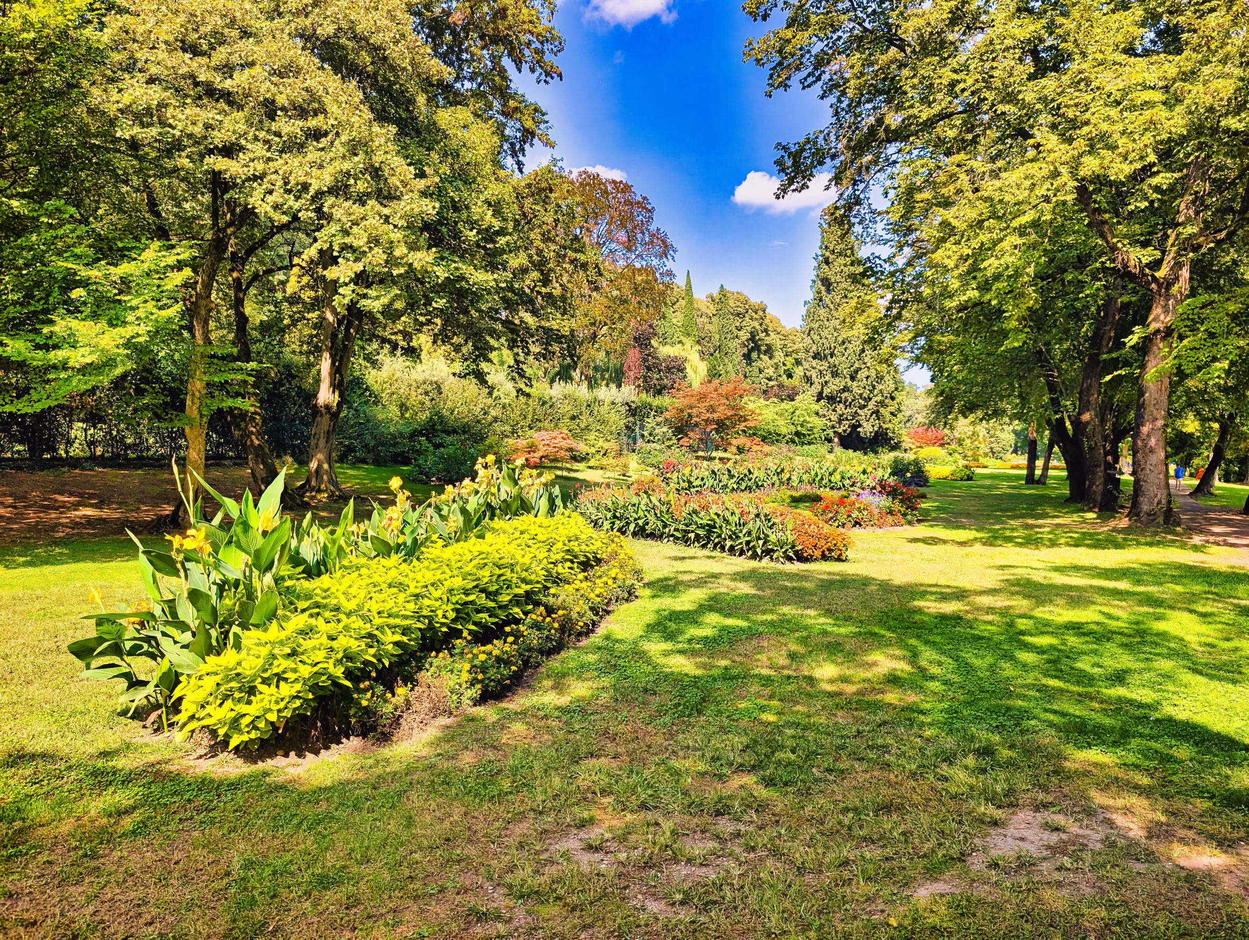 Flowerbeds and lawns beneath mature trees at Parco Giardino Sigurtà