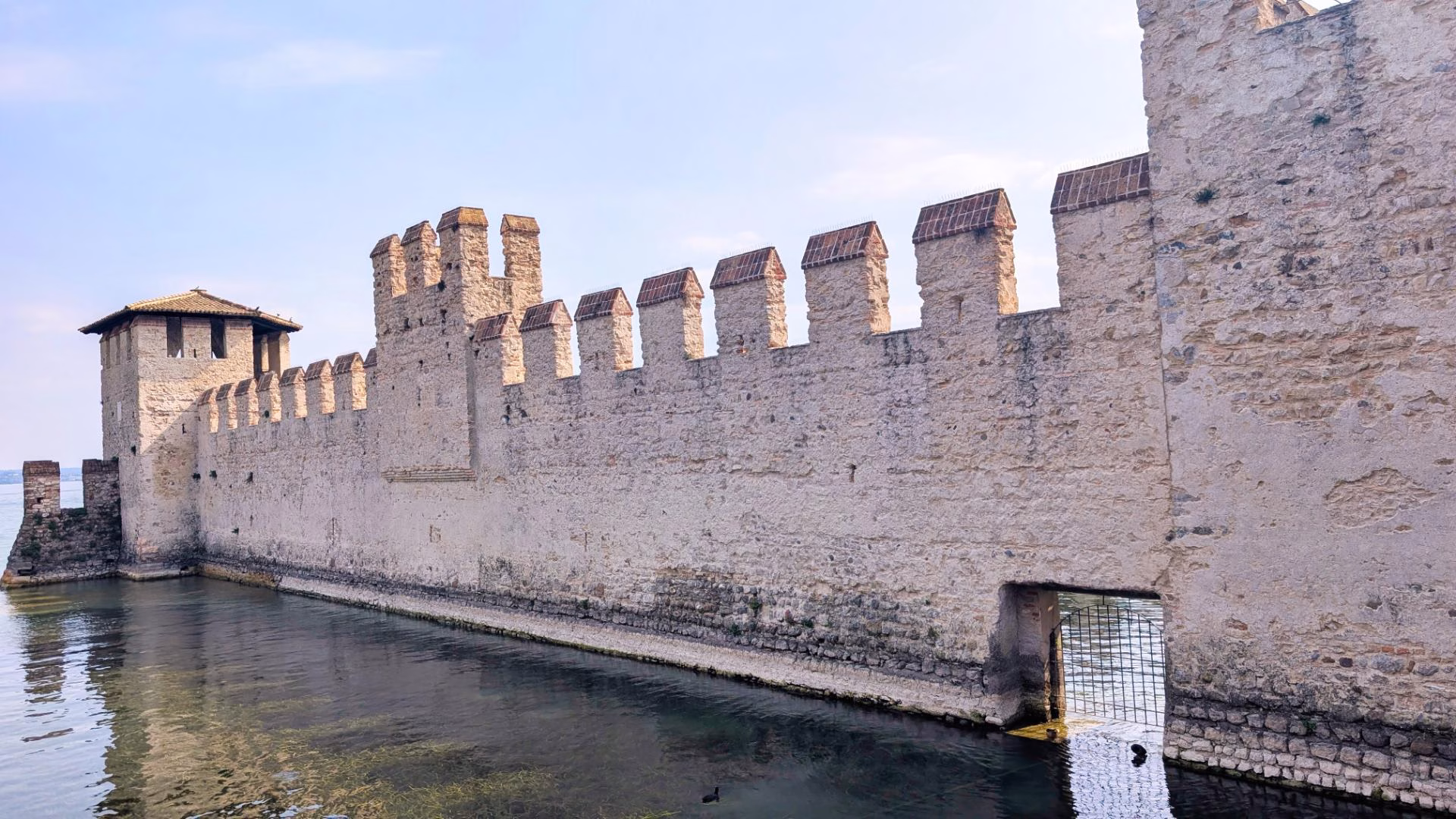 Crenellated stone walls surrounding Scaligero Castle’s fortified harbour