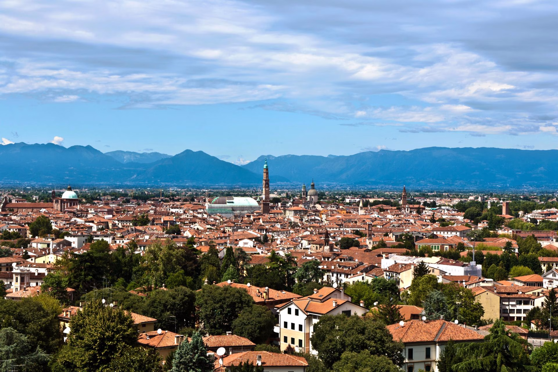 Vicenza’s rooftops, Basilica Palladiana and Torre Bissara seen from Monte Berico, with mountains beyond