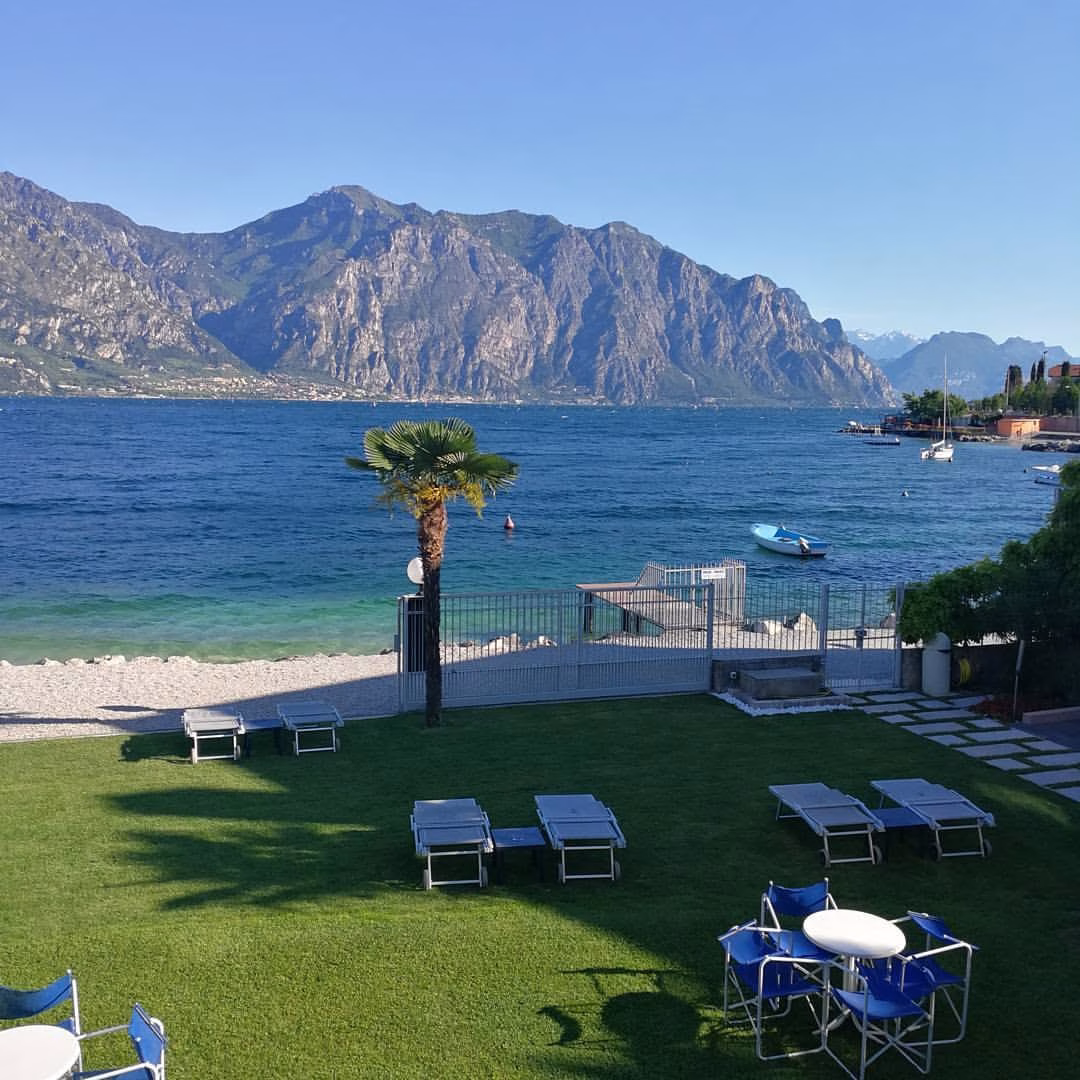 Sunloungers and parasols on Hotel Castello’s lakeside lawn