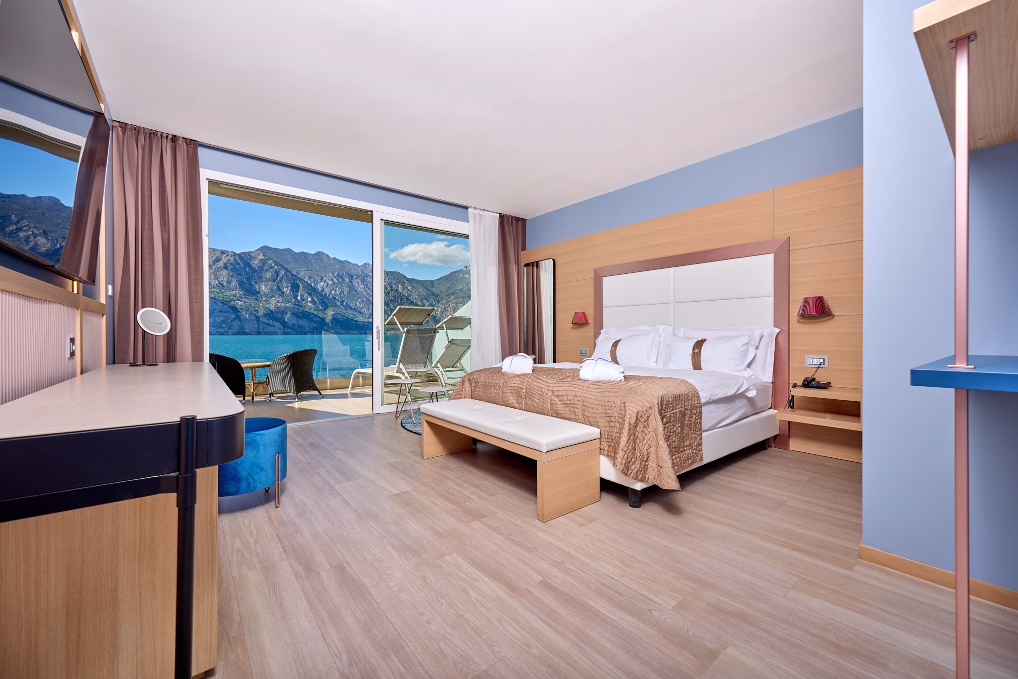 Suite Miralago bedroom with pink and blue furnishings and lake-view balcony doors